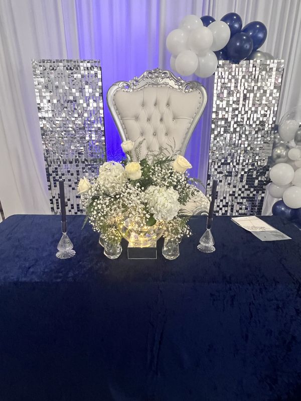 Sweetheart table with throne chair, sequin backdrops and floral arrangement