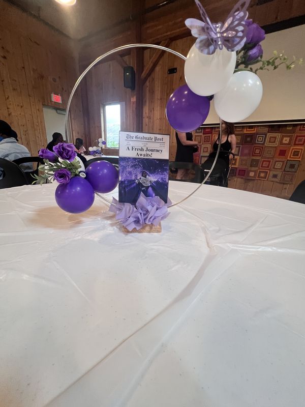 Personalized graduation centerpiece with custom newspaper, purple balloons and butterflies
